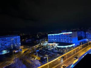 a city at night with cars parked in a parking lot at Apartament 2 dormitoare ultracentral modern in Craiova +5 photos