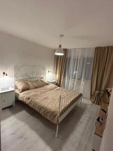 a bedroom with a bed and a large window at Apartament 2 dormitoare ultracentral modern in Craiova