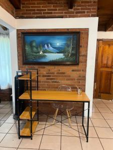 un televisor colgado en una pared de ladrillo con una mesa en Cabaña cerca del Santuario Valle de Bravo, en Valle de Bravo