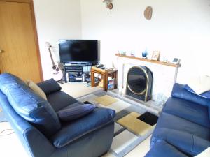 sala de estar con sofá y chimenea en Jomarnic B&B, en Lossiemouth
