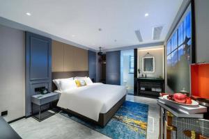Premier City Comfort Hotel Suizhou Wuyue Plaza في Suizhou: غرفة نوم بها سرير أبيض كبير وحمام