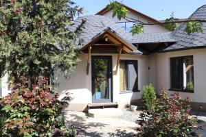 a white house with a door and some plants at Happy Nomads - Modern Yurt Cottages & Breakfast in Karakol