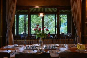 a wooden table with a vase of flowers on it at Chapa Ecolodge in Sapa