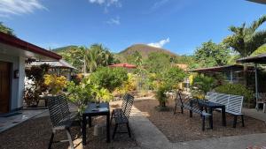a patio with a table and chairs and a mountain at Angel Gabriel Homestay in Coron