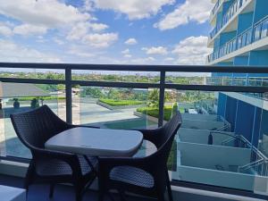 a balcony with two chairs and a table at M&R Condotel Azure North in San Fernando