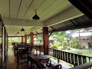 a screened porch with a table and chairs on it at Baantawan Guesthouse Pai in Pai