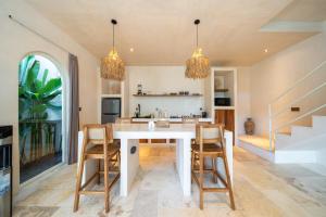 a kitchen with a white table and chairs at Mayiki Boutique Hotel in Uluwatu