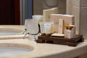 a bathroom counter with toiletries on a sink at Capitol Hotel in Varna City +31 photos