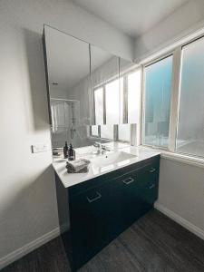 a bathroom with a sink and a large mirror at Self-Contained Wanaka GuestHouse in Wanaka