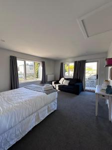 a bedroom with a large bed and a couch at Self-Contained Wanaka GuestHouse in Wanaka