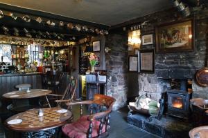 a bar with tables and chairs and a fireplace at The Lamb Inn in Chinley