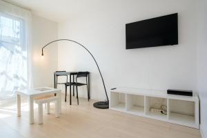 a white living room with a white table and a lamp at Studio Cosy entre Disney et Noisy Le Grand in Noisy-le-Grand