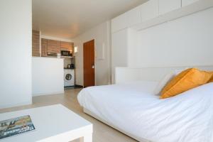 a white bedroom with a bed and a table at Studio Cosy entre Disney et Noisy Le Grand in Noisy-le-Grand