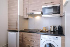 a kitchen with a washing machine and a microwave at Studio Cosy entre Disney et Noisy Le Grand in Noisy-le-Grand +3 photos