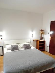 sypialnia z dużym białym łóżkiem z 2 poduszkami w obiekcie Apartment House Nono w mieście Povljana