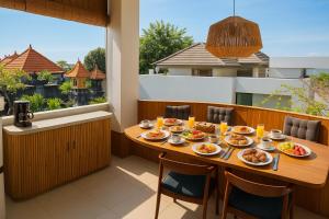 a table on a balcony with food on it at Samastiti Bingin in Uluwatu