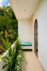a balcony with a bench and plants at Samastiti Bingin in Uluwatu