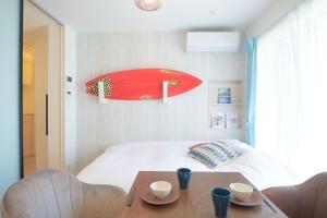 a room with a bed with a surfboard on the wall at Z LAND Enoshima by Tranova in Fujisawa