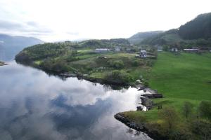 an aerial view of a river with houses and trees at Kleppa Gard & Glamping in Hjelmeland +3 photos