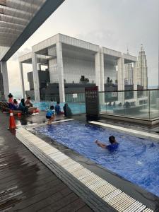 a group of people in a swimming pool on a building at Bintang Lux Service Suites Platinum KLcc in Kuala Lumpur