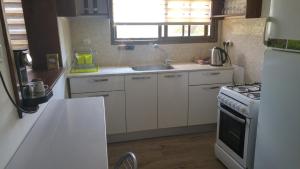 a kitchen with white cabinets and a sink and a stove at Dror Winery in Kefar Shammay