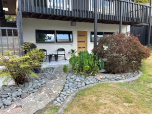 a house with a patio with rocks and plants at Riverside Apartment in Hamilton