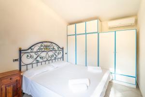 a bedroom with a large white bed with two chairs at Premium Villa Eleonora, 250m to beach in Fort Village