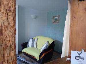 a yellow chair in a room with a table at Le Balcon in Sélestat