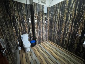 bagno con servizi igienici e pavimento in legno di Ciel Star Anuradhapura a Anuradhapura