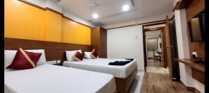 a hotel room with two beds and a bathroom at Alfouz Guest House in Chennai +34 photos