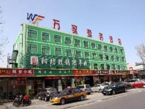 un bâtiment vert avec des voitures garées devant lui dans l'établissement Beijing Wanjia Traders Hotel, à Pékin