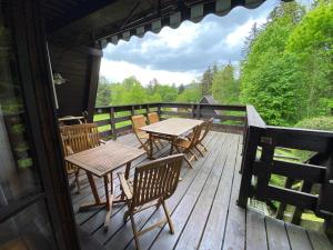 a deck with tables and chairs on a cabin at Chata Pastviny in Pastviny
