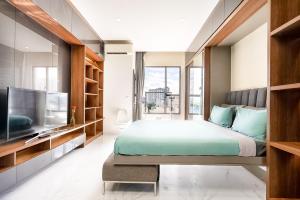 a bedroom with a large bed and a flat screen tv at MKA Summerset Rivergate Saigon Central in Ho Chi Minh City