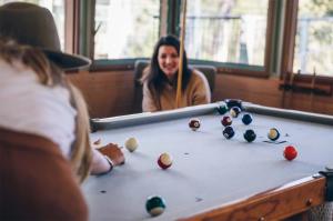 une femme assise devant un billard dans l'établissement Bombah Point Eco Cottages, à Bulahdelah