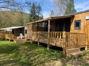 una cabina in legno con portico e terrazza di Mobil-Home 6 à 8 personnes ad Ascou