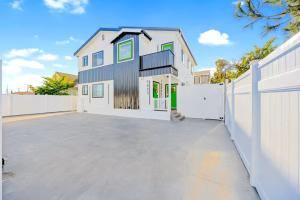 a house with a white fence and a driveway at D- Hip NoHo Haven Hot Tub - Family - Parking in North Hollywood