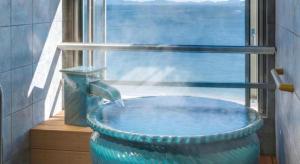 a large blue tub in a bathroom with a window at Shinojima Royal Hotel Kasuisou in Minamichita +165 photos