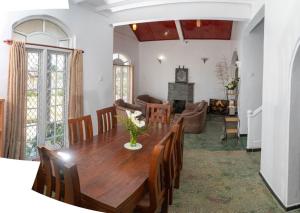 een eetkamer en een woonkamer met een houten tafel bij Trillium Villa in Nuwara Eliya