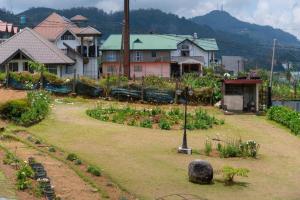 un jardin devant un village avec des maisons dans l'établissement Trillium Villa, à Nuwara Eliya