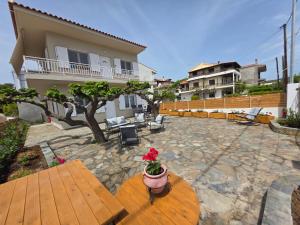 a patio with a wooden table with a vase of flowers at Sea Lilly in Agia Anna