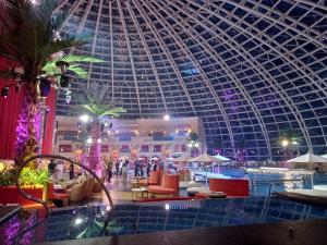 a large building with a domed ceiling and a swimming pool at Modern 1BR with Balcony Facing Infinity Pool Manila Bay Sunset Near Airports OKADA Solaire MOA in Manila