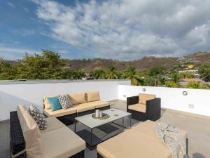 a patio with couches and tables on a roof at Miram #4 - Three Bedroom Villa Across The Beach in Coco