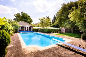 ein Swimmingpool in einem Garten mit einem Haus in der Unterkunft Rectory Farm in Cambridge + 54 Fotos