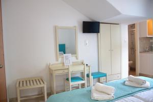 a room with a bed and a desk and a mirror at EYTYXHS Studios in Palaiochora