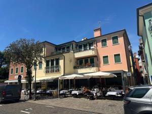 a building with tables and umbrellas on a city street at Casa Vita di Mare in Caorle