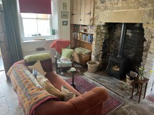 ein Wohnzimmer mit Couch und Kamin in der Unterkunft Doffers Cottage in Skipton