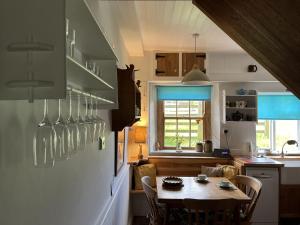 eine Küche mit Tisch und ein Esszimmer in der Unterkunft Doffers Cottage in Skipton