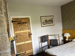 Schlafzimmer mit einer Holztür und einem Bett in der Unterkunft Doffers Cottage in Skipton