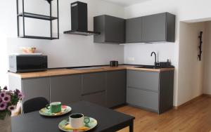 a kitchen with gray cabinets and a table with two cups at Texlhof - Stella Alpina in Parcines