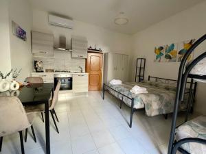 a kitchen and a living room with a bed and a table at Ortensia Apartment in Giungano